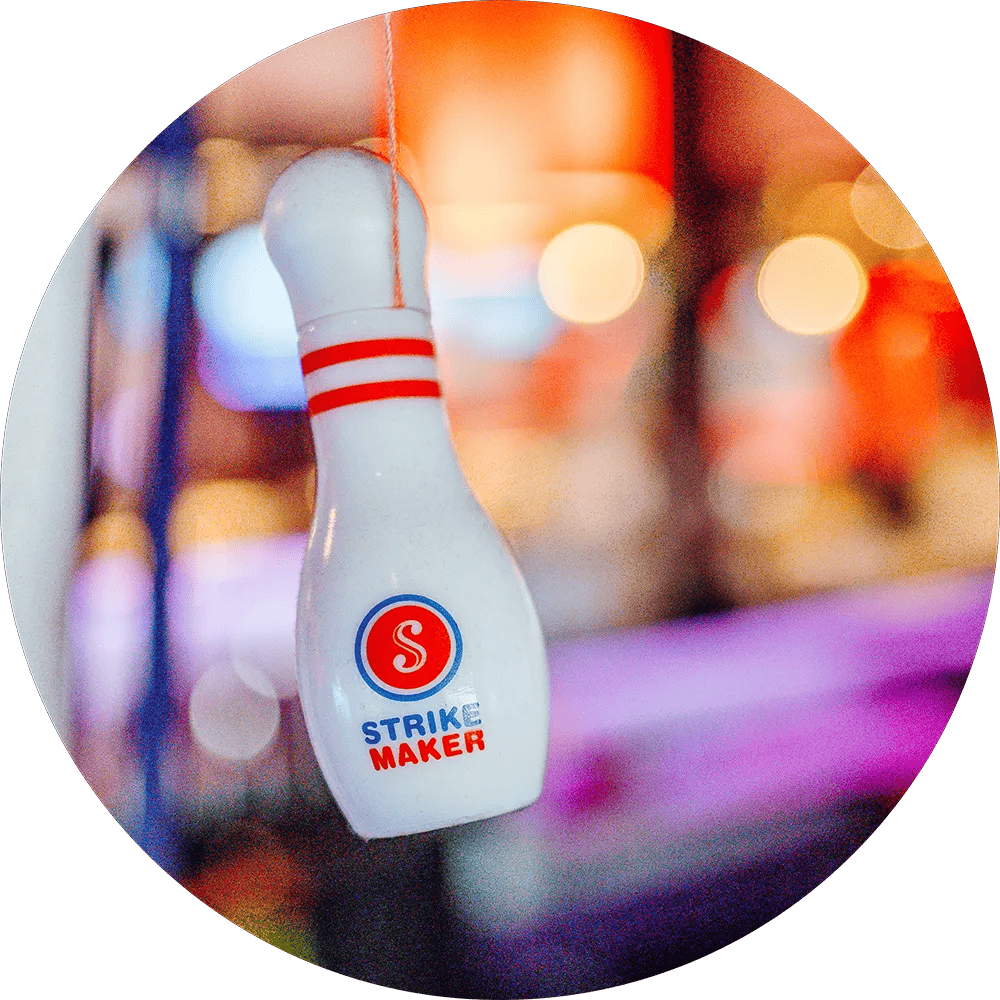 weißer Bowling Pin vor verschwommenen Lichtern im Hintergrund